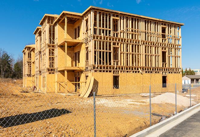 workers protected by temporary barrier fence during building maintenance in Alva